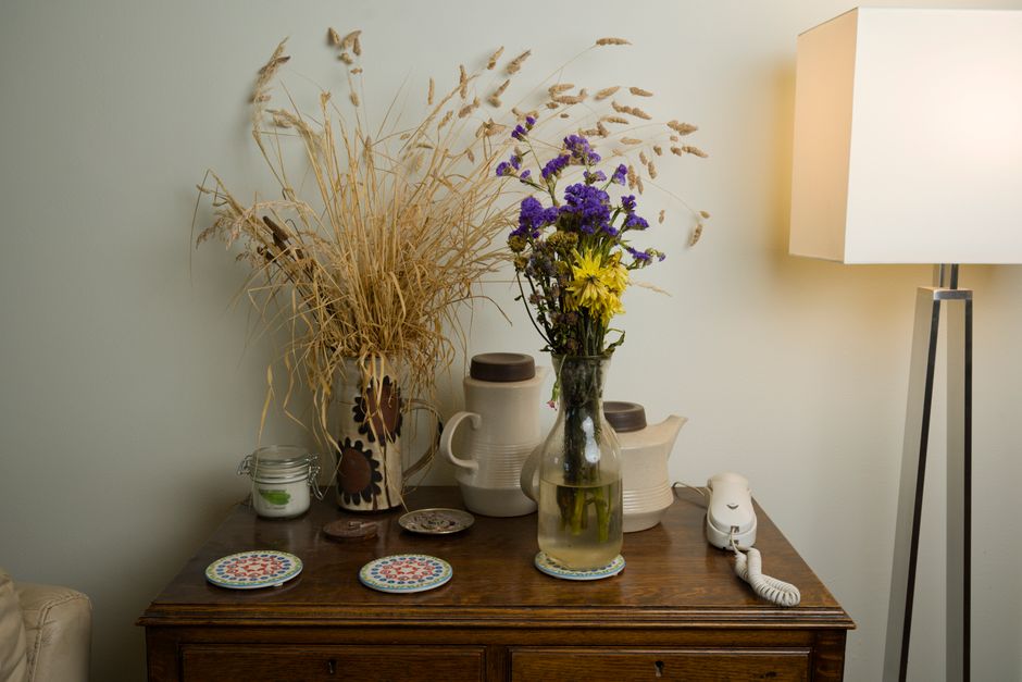 Charming rustic indoor scene with dried flowers, a lamp, and vintage decor on a wooden table.