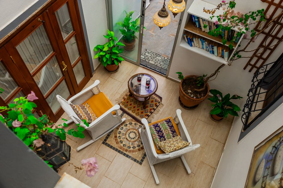 Inviting indoor patio with chairs, table, and lush plants creating a cozy retreat.